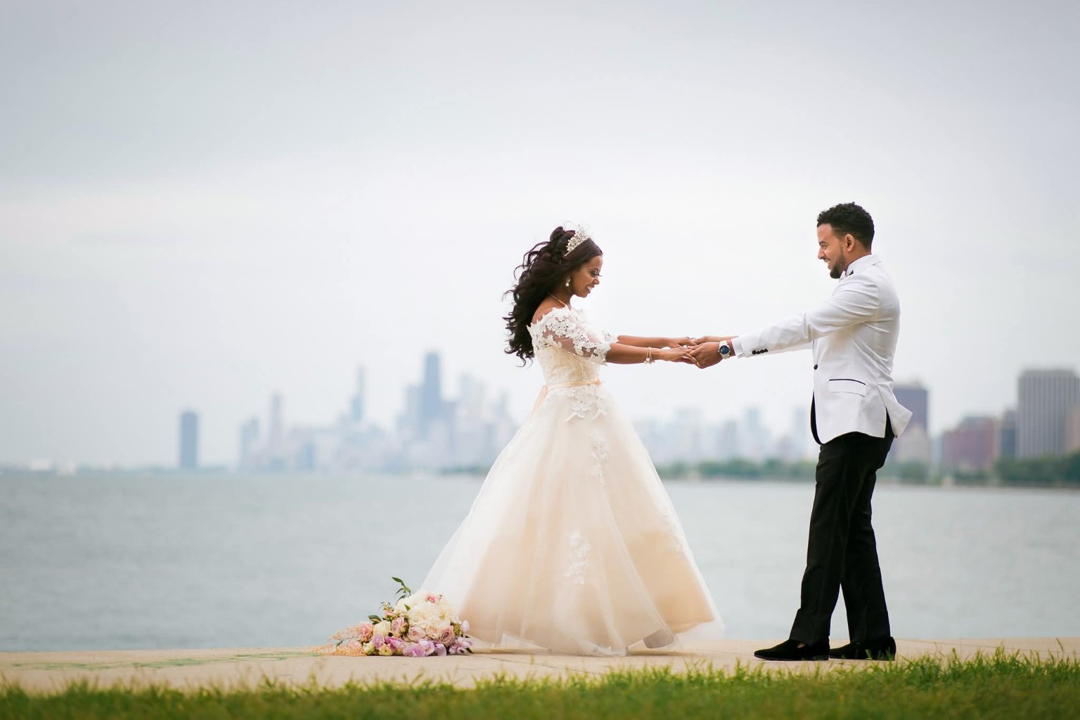 Our wedding photograph: a couple holding hands by the waterfront, with a city skyline behind them.